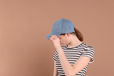 Photo of Woman in stylish baseball cap on beige background. Mockup for design