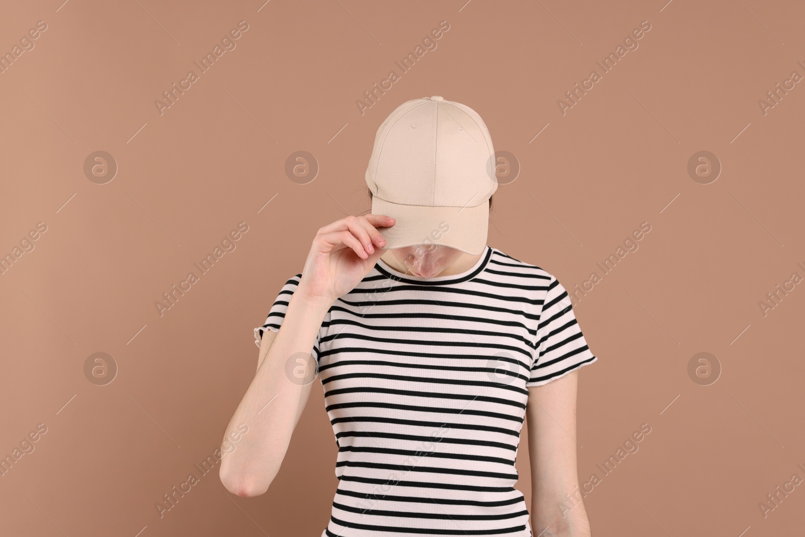 Photo of Woman in stylish baseball cap on beige background. Mockup for design