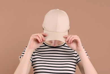 Photo of Woman in stylish baseball cap on beige background. Mockup for design