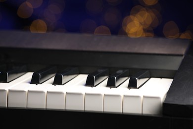 Piano against blurred lights, closeup. Bokeh effect