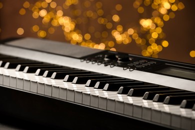 Photo of Piano against blurred lights, closeup. Bokeh effect