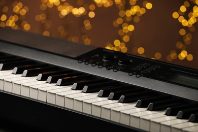 Photo of Piano against blurred lights, closeup. Bokeh effect