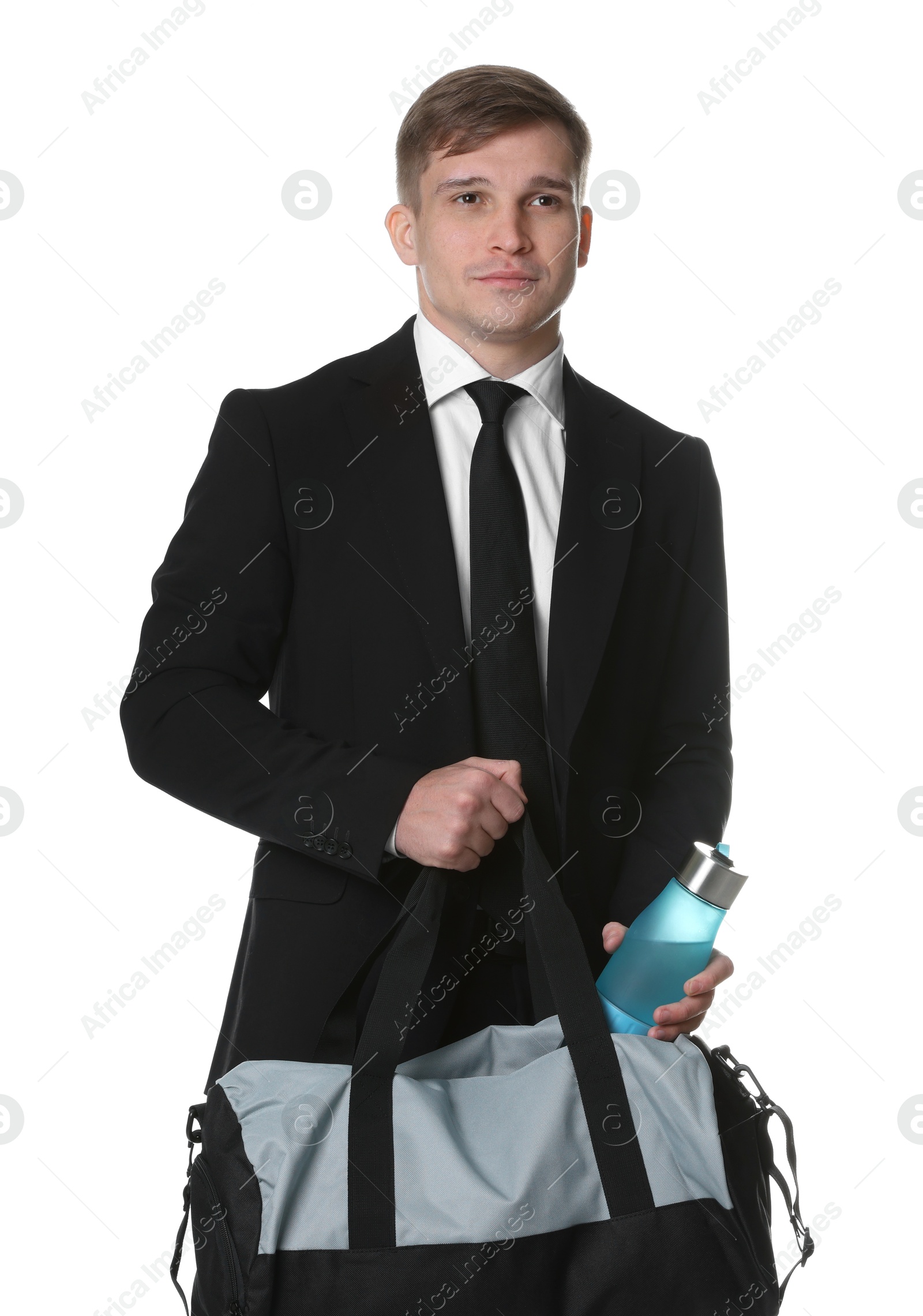 Photo of Young man in suit putting bottle of water into gym bag on white background