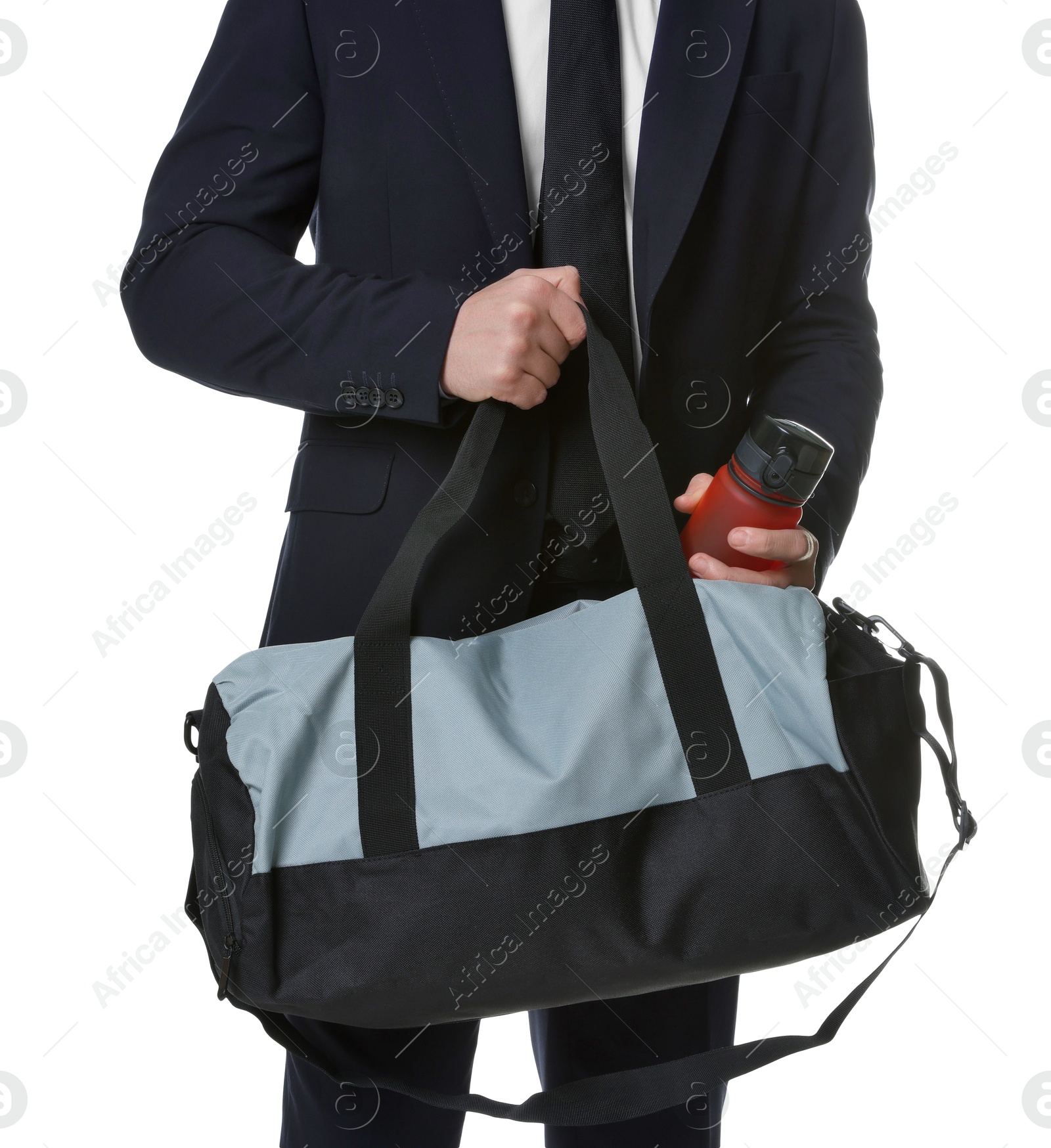 Photo of Man in suit putting bottle of water into gym bag on white background, closeup