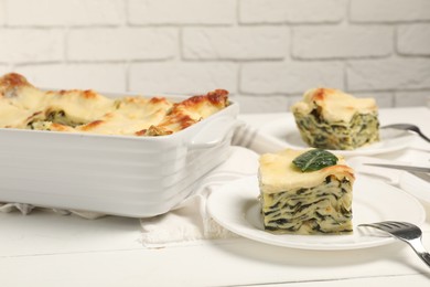 Photo of Delicious spinach lasagne served on white wooden table