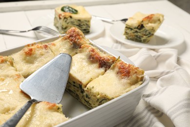 Photo of Delicious spinach lasagne served on white table