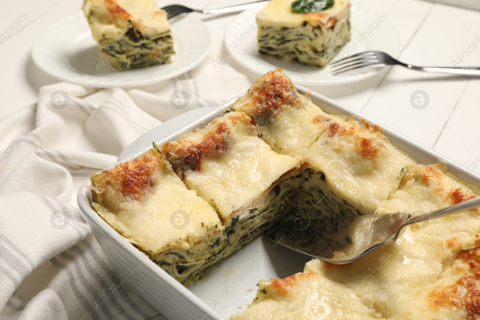 Photo of Delicious spinach lasagne served on white table