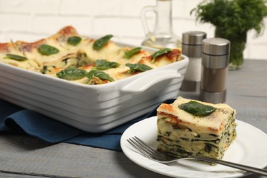 Photo of Delicious spinach lasagne on grey wooden table, closeup