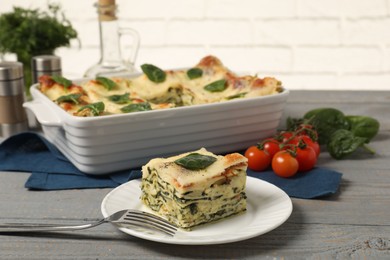 Photo of Delicious spinach lasagne on grey wooden table