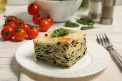 Photo of Piece of delicious spinach lasagne served on white wooden table, closeup