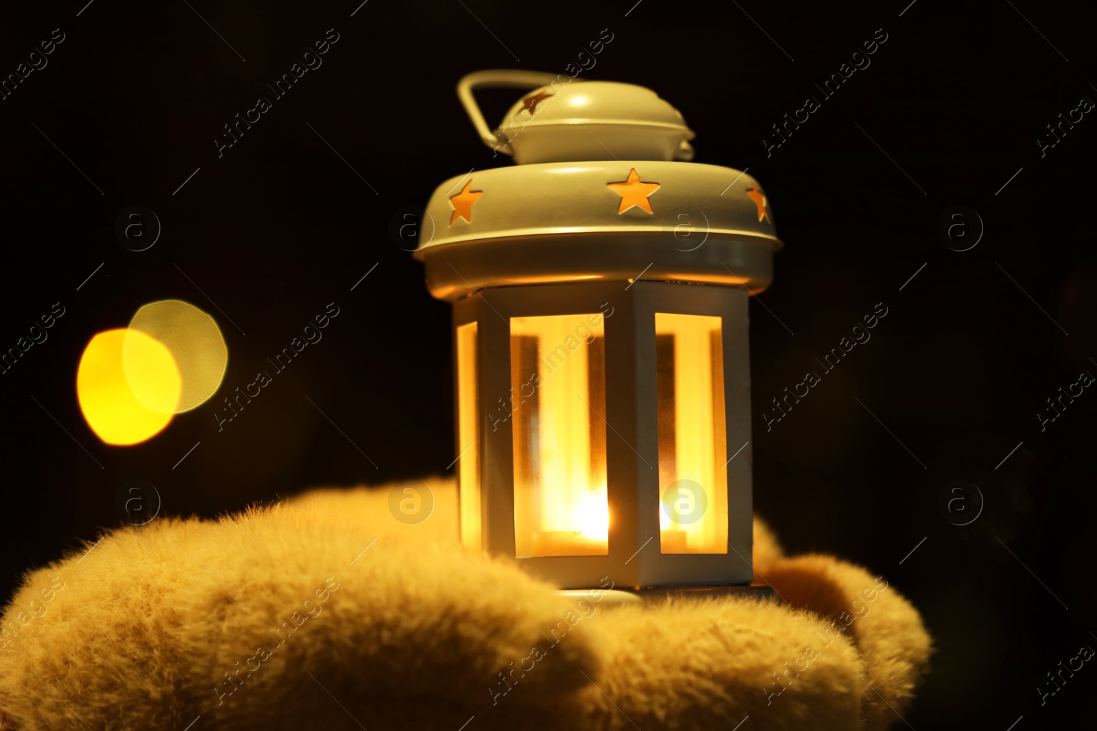 Photo of Woman holding Christmas lantern with burning candle in darkness, closeup