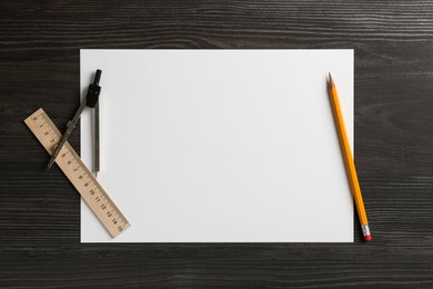 Photo of Ruler, paper, compass and pencil on black wooden table, flat lay. Space for text