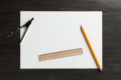 Photo of Ruler, paper, compass and pencil on black wooden table, flat lay. Space for text