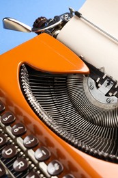 Photo of Old vintage typewriter on blue background, closeup