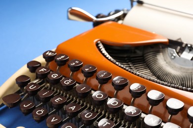 Photo of Old vintage typewriter on blue background, closeup