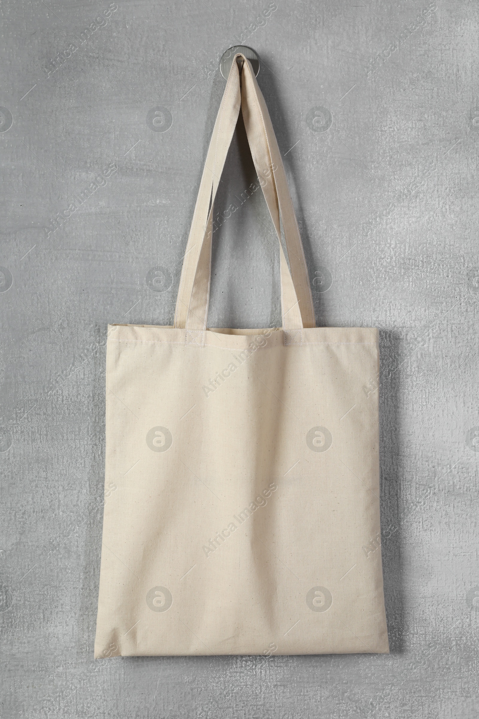 One eco bag hanging on grey wall. Mockup for design Photo of One eco bag hanging on grey wall. Mockup for design
