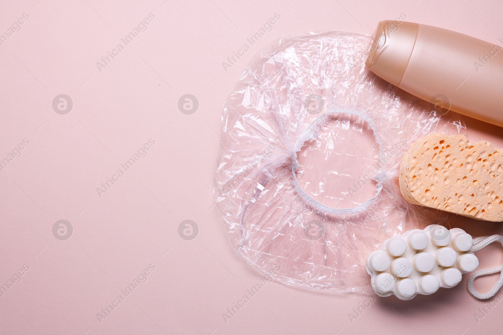 Photo of Shower cap and bath accessories on beige background, flat lay. Space for text