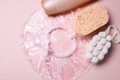 Photo of Shower cap and bath accessories on beige background, flat lay