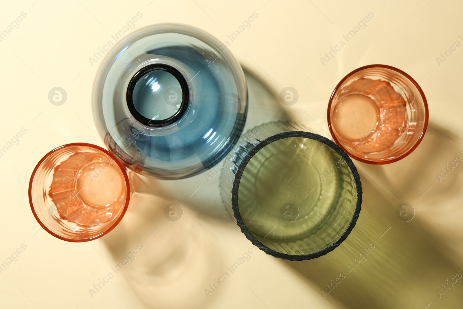 Photo of Empty glass vases on beige background, flat lay