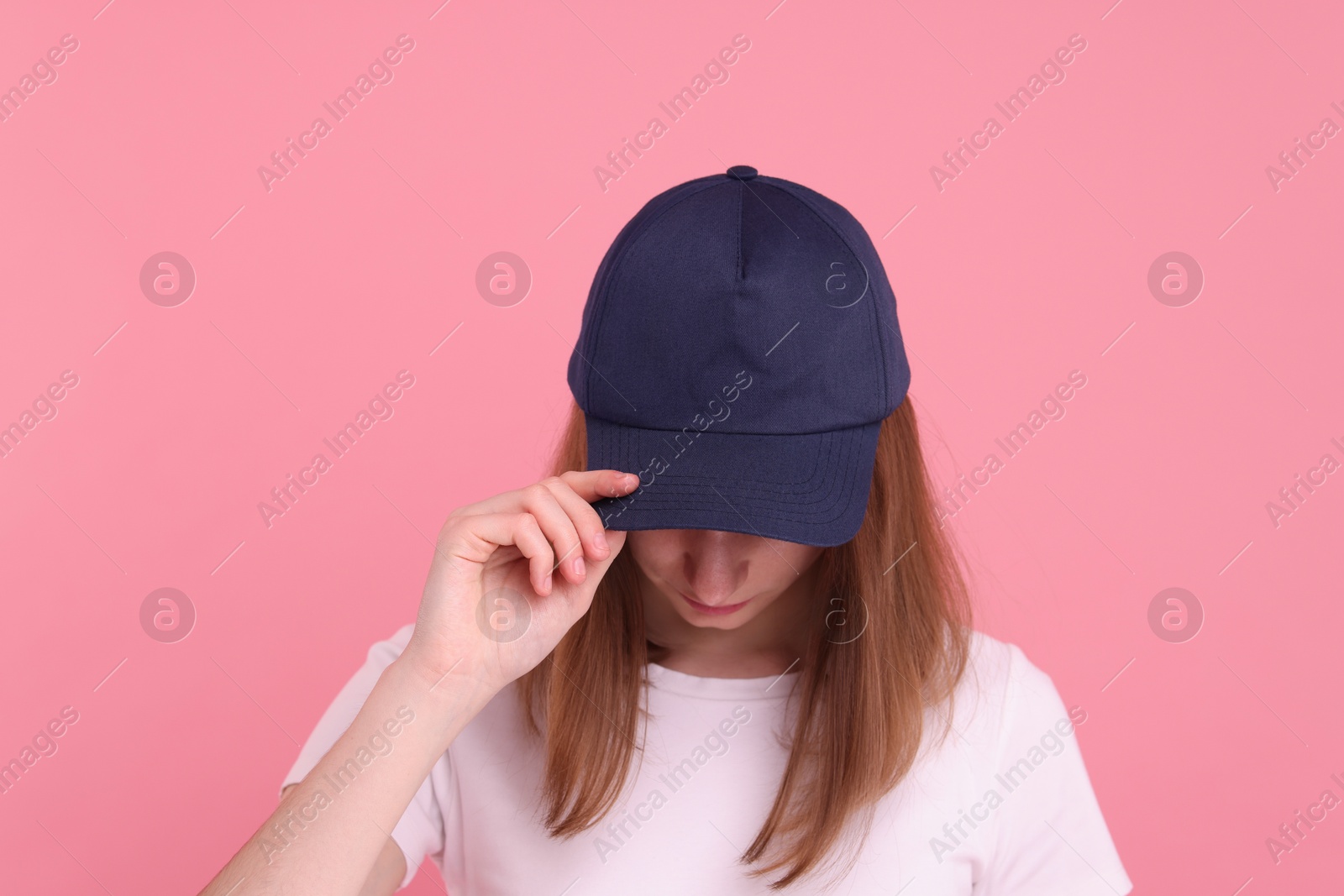 Photo of Woman in stylish baseball cap on pink background. Mockup for design