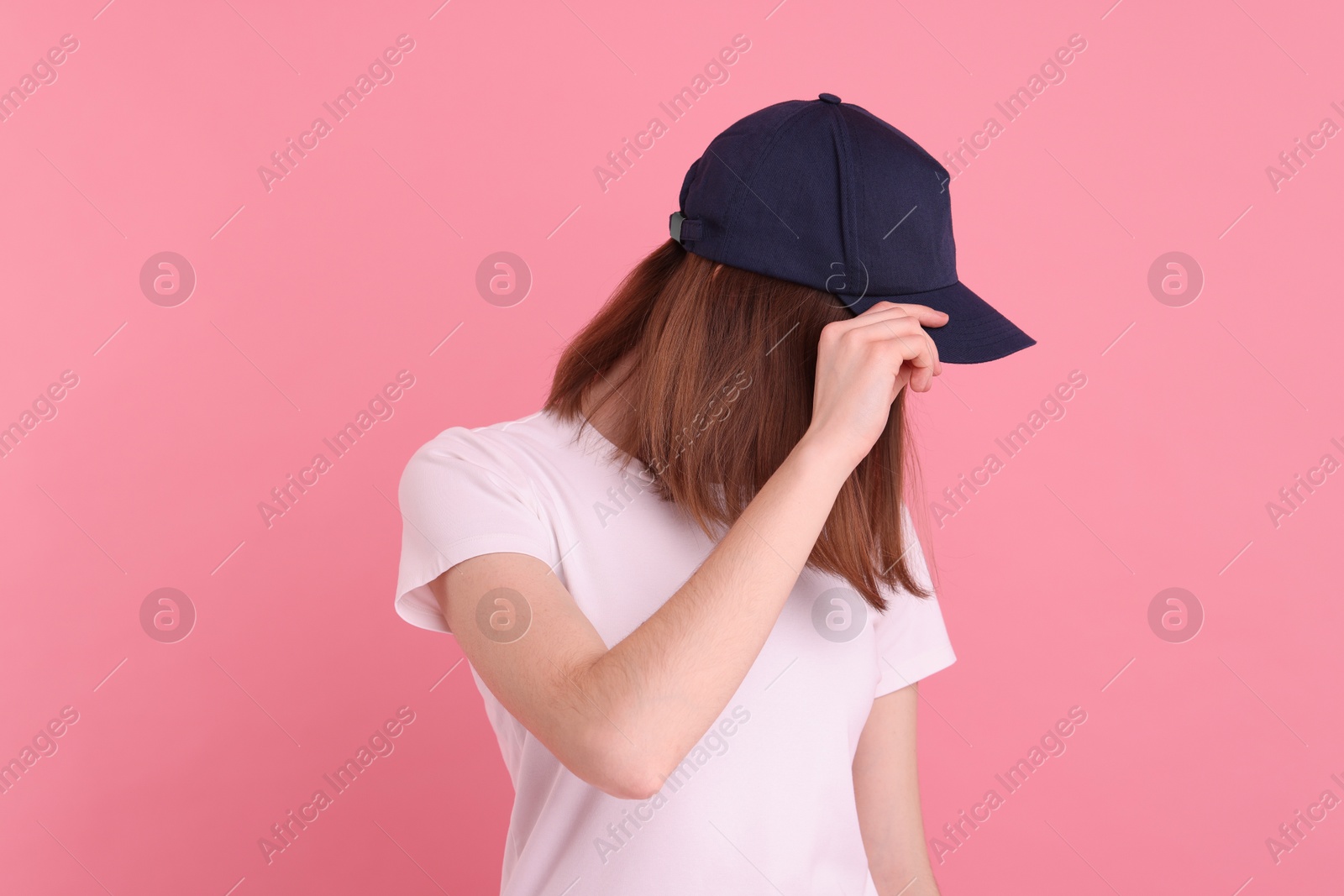 Photo of Woman in stylish baseball cap on pink background. Mockup for design