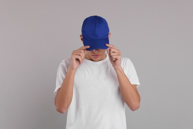 Photo of Man in stylish baseball cap on grey background. Mockup for design