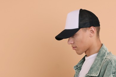 Photo of Man in stylish baseball cap on beige background. Mockup for design