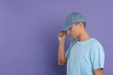 Photo of Man in stylish baseball cap on violet background. Mockup for design