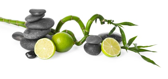 Photo of Spa composition with limes, massage stones and bamboo stems isolated on white