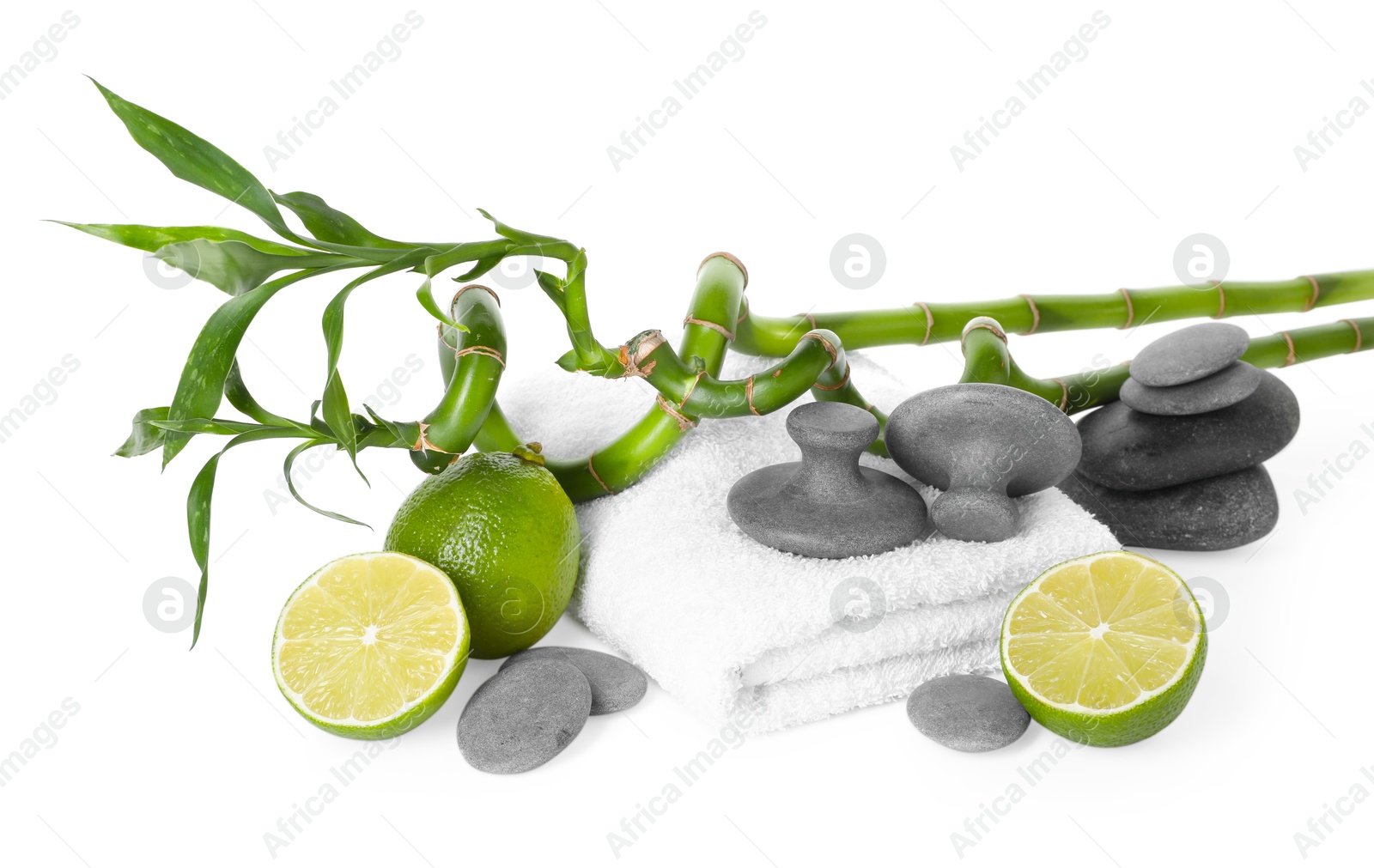 Spa composition with limes, massage stones, towel and bamboo stems isolated on white Photo of Spa composition with limes, massage stones, towel and bamboo stems isolated on white