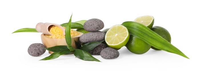 Photo of Spa composition with limes, massage stones, sea salt and green leaves isolated on white
