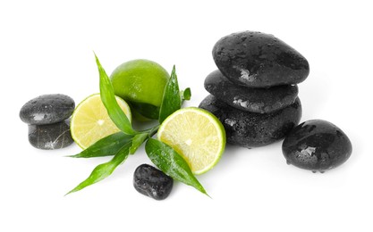 Photo of Spa composition with limes, massage stones and green leaves isolated on white