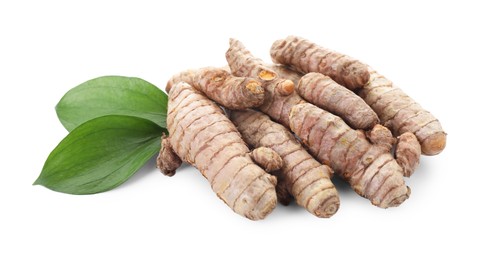 Photo of Raw turmeric roots and green leaves isolated on white