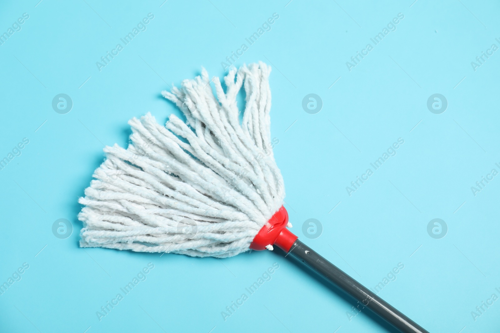 Photo of String mop on light blue background, top view. Cleaning equipment