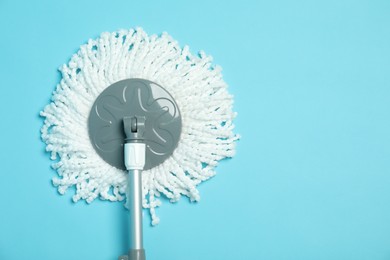 Photo of String mop on light blue background, top view. Space for text