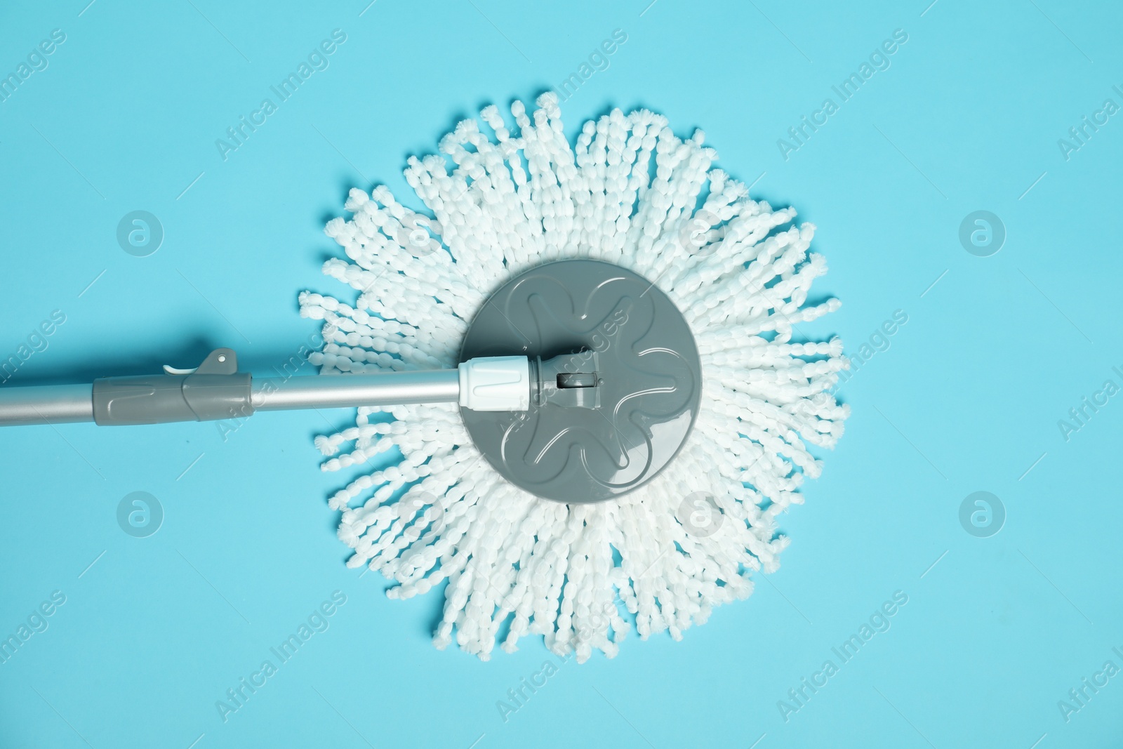 Photo of String mop on light blue background, top view. Cleaning equipment