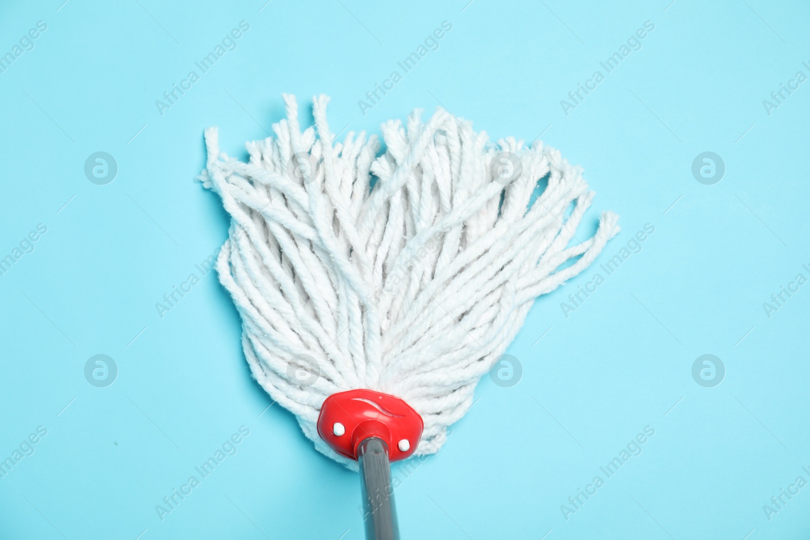 Photo of String mop on light blue background, top view. Cleaning equipment