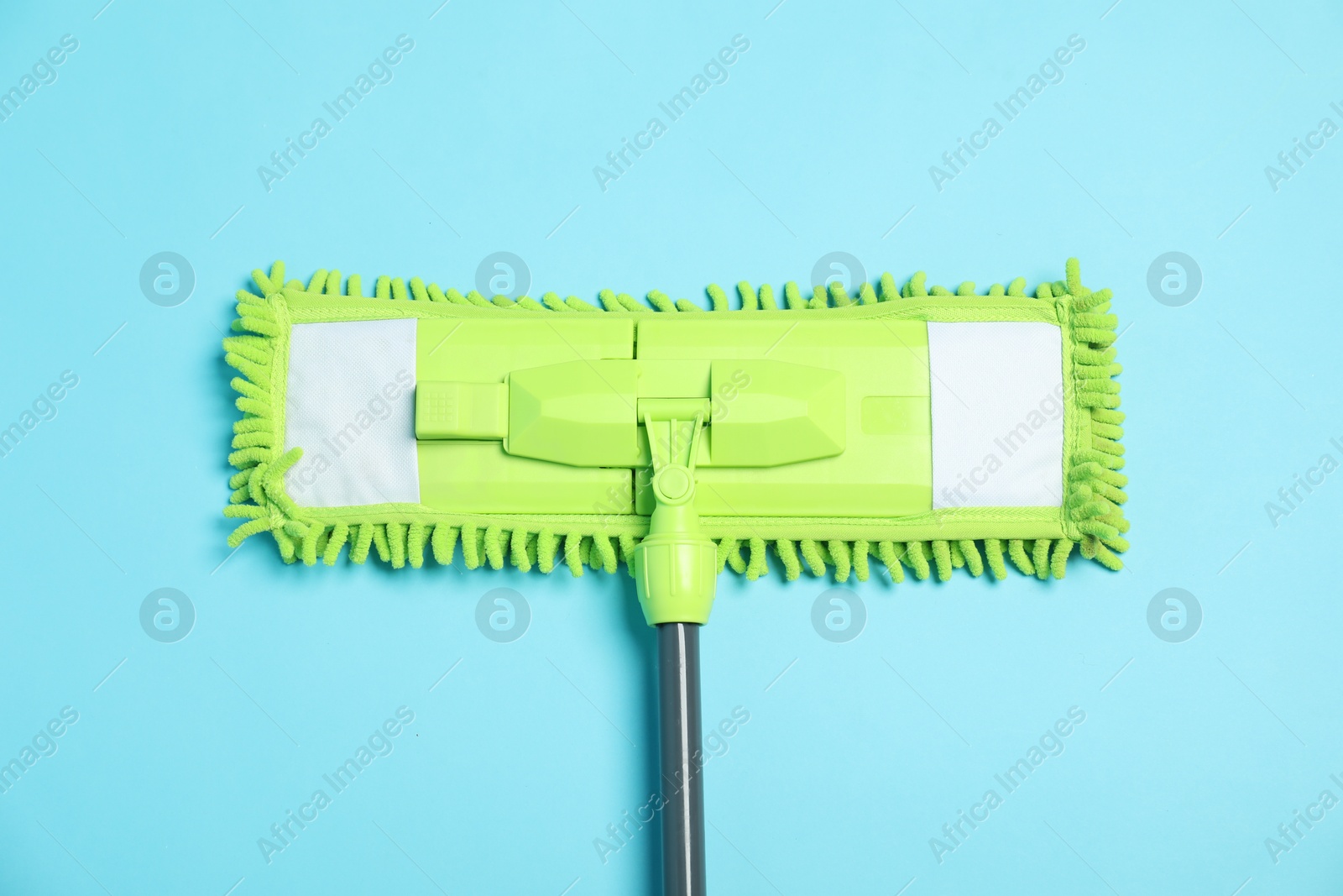 Photo of Microfiber mop on light blue background, top view. Cleaning equipment