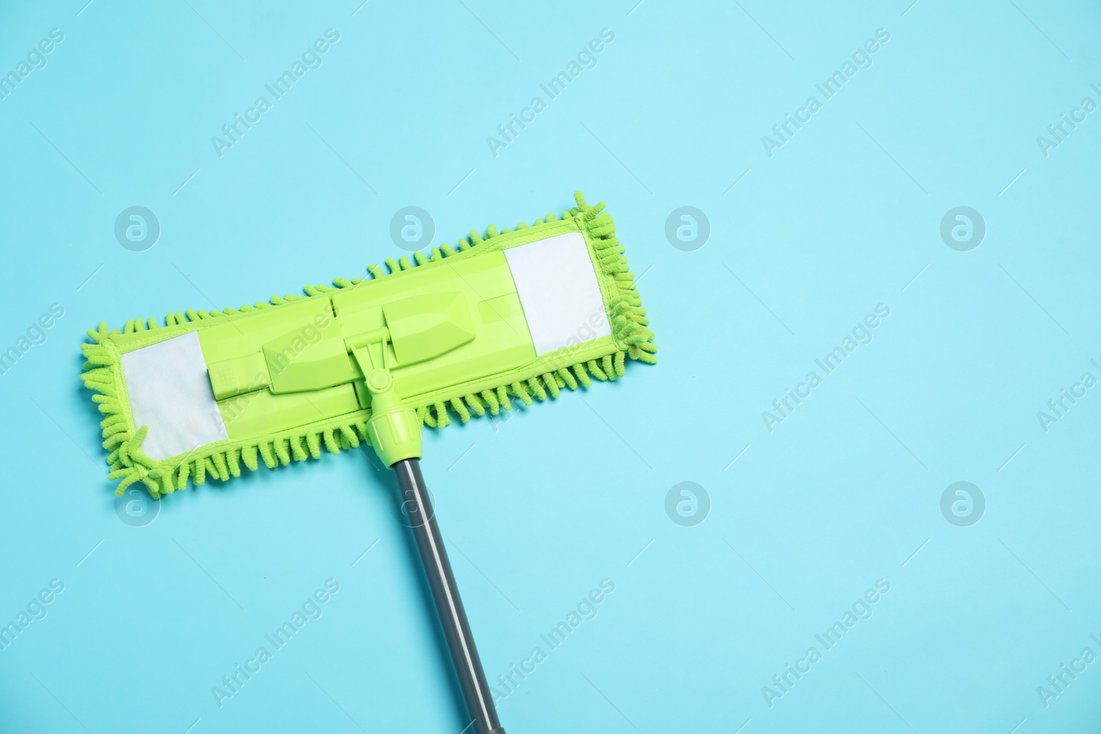 Photo of Microfiber mop on light blue background, top view. Space for text