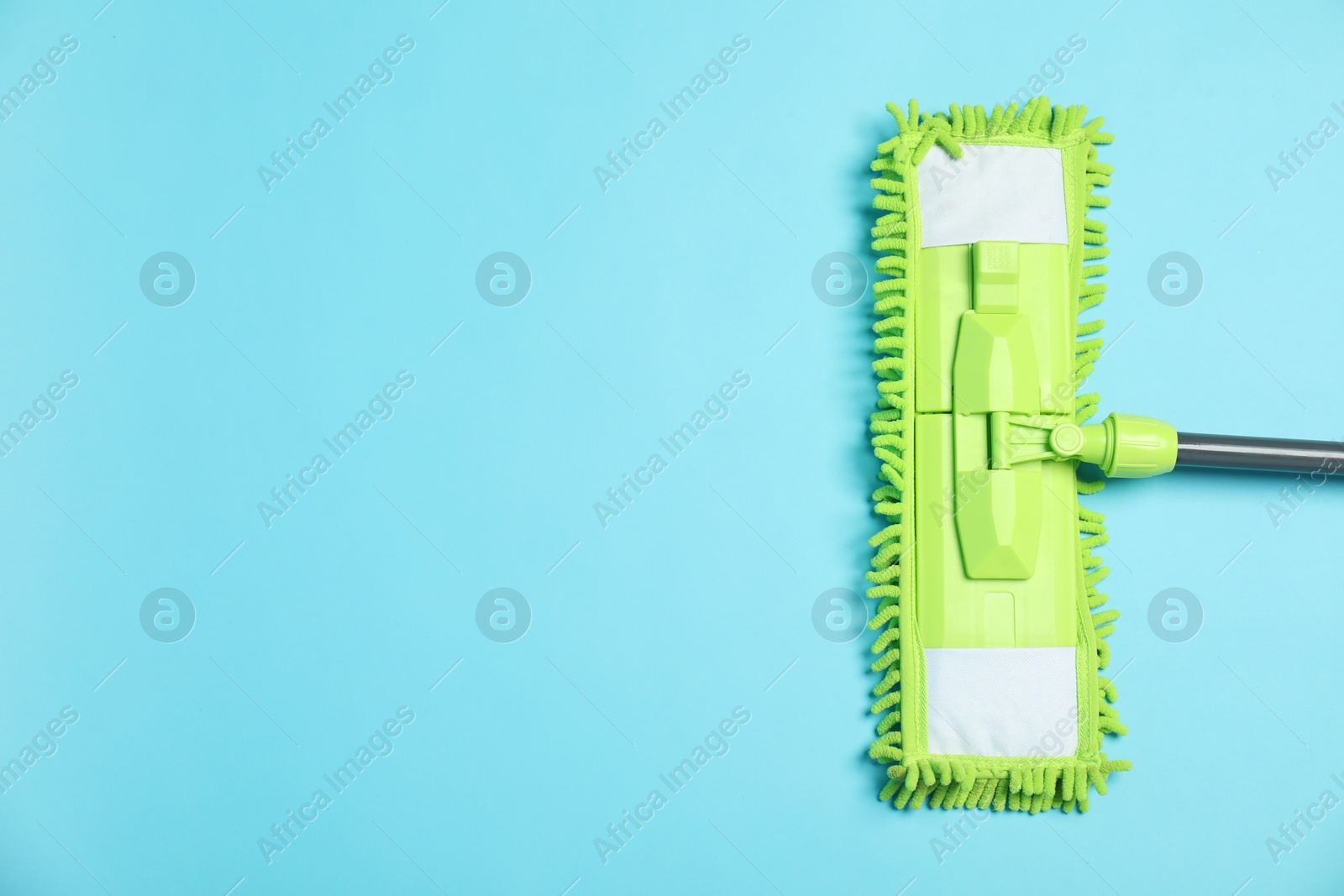 Photo of Microfiber mop on light blue background, top view. Space for text