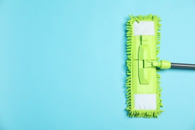 Photo of Microfiber mop on light blue background, top view. Space for text