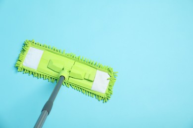 Photo of Microfiber mop on light blue background, top view. Space for text