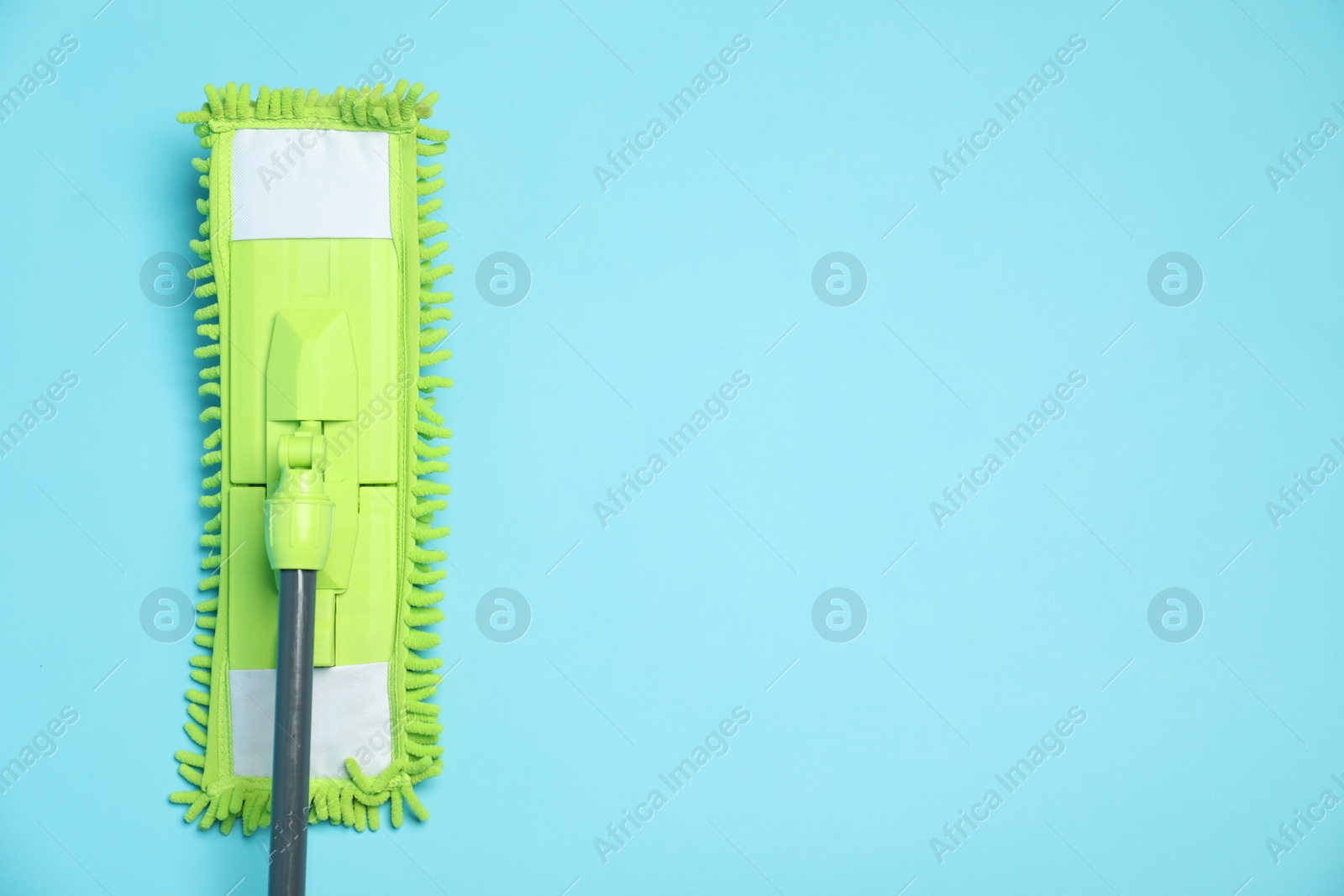 Photo of Microfiber mop on light blue background, top view. Space for text