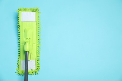 Microfiber mop on light blue background, top view. Space for text