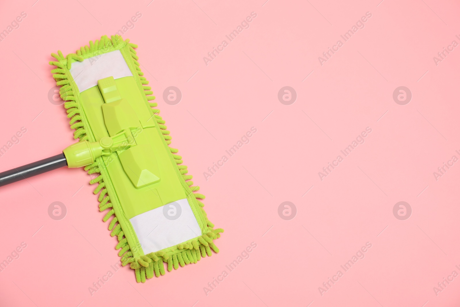 Photo of Microfiber mop on pink background, above view. Space for text