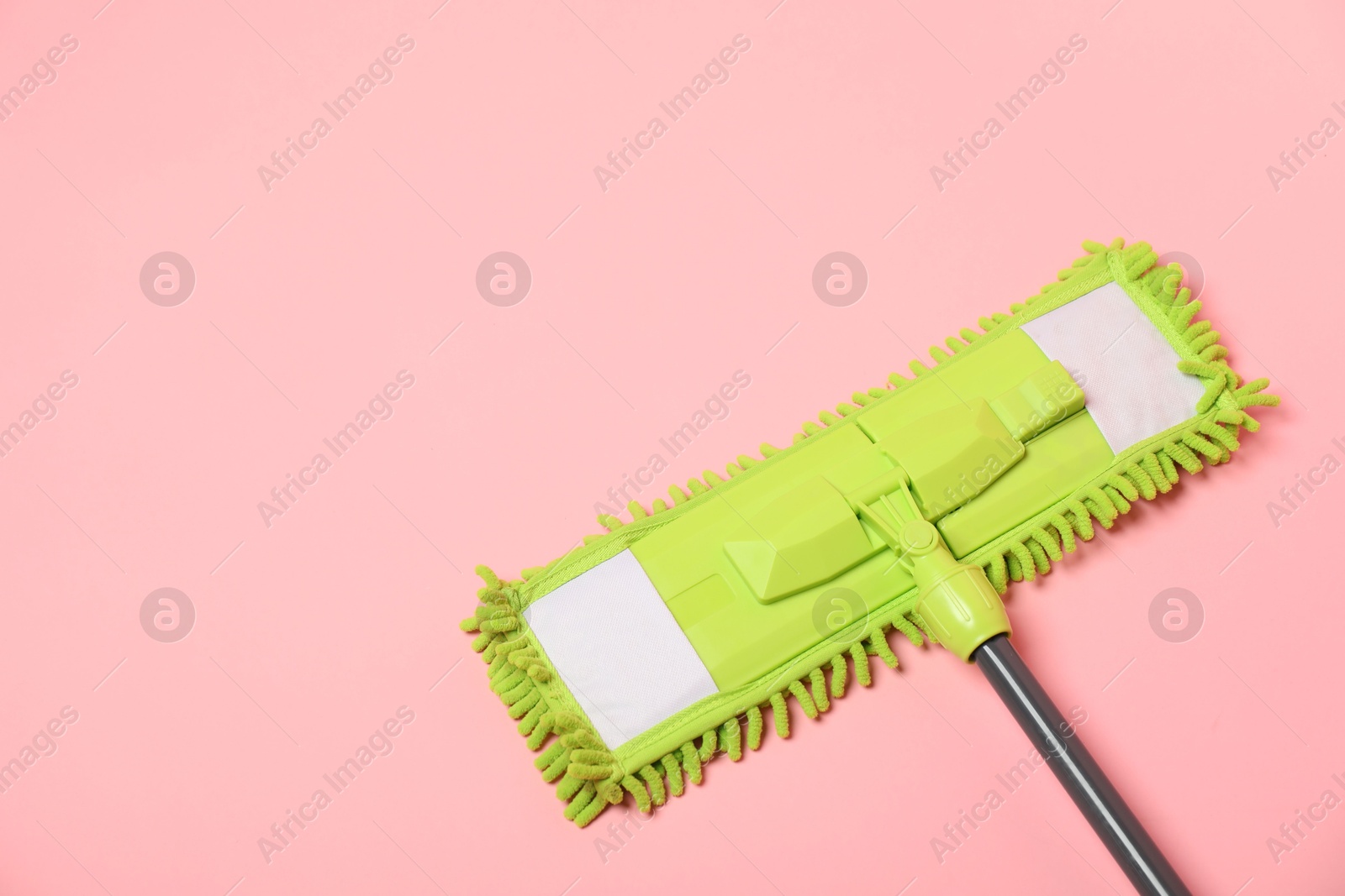 Photo of Microfiber mop on pink background, above view. Space for text