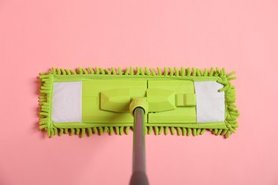 Photo of Microfiber mop on pink background, top view