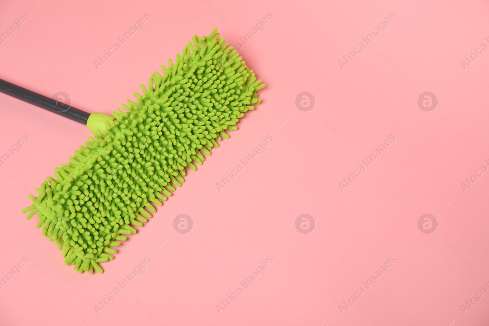 Photo of Microfiber mop on pink background. Space for text