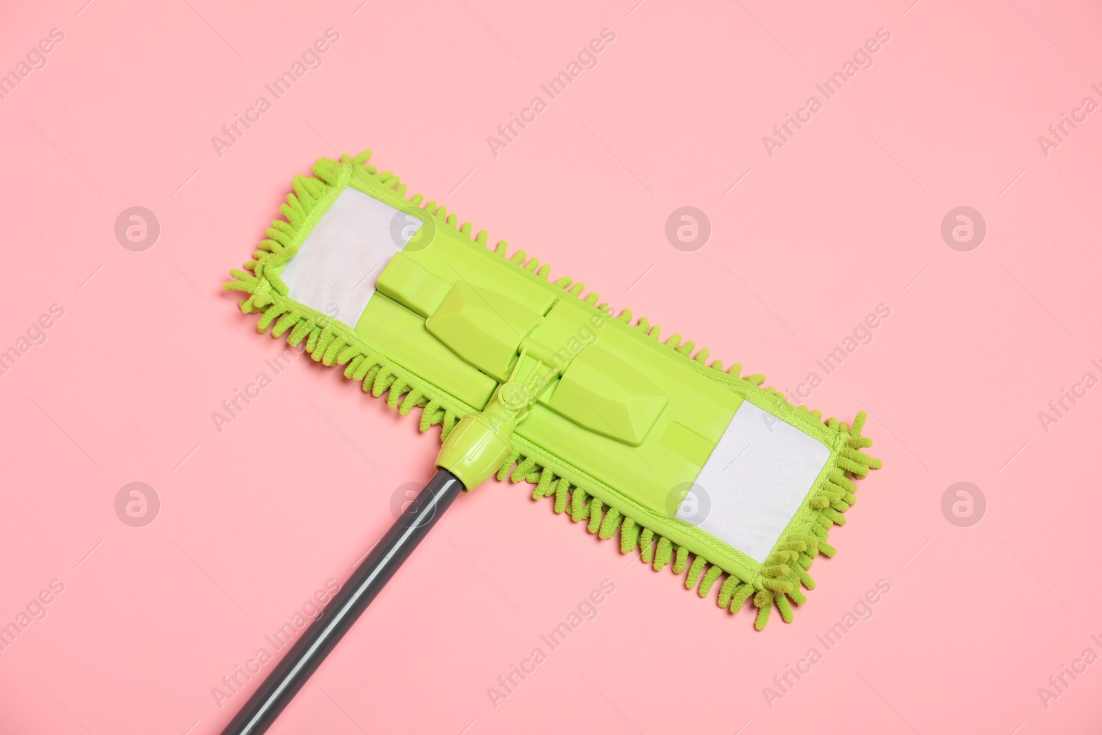 Photo of Microfiber mop on pink background, top view