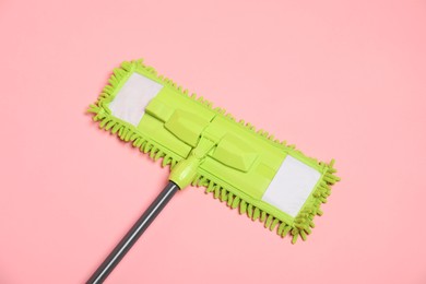 Photo of Microfiber mop on pink background, top view